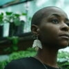A model in a garden wearing NOKI's upcycled jewellery