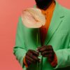 Man in Colorful Suit Holding a Flower