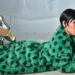 Portrait of fashionable woman in green fur coat with silver boots